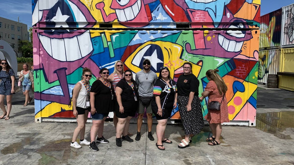 group in front of a mural