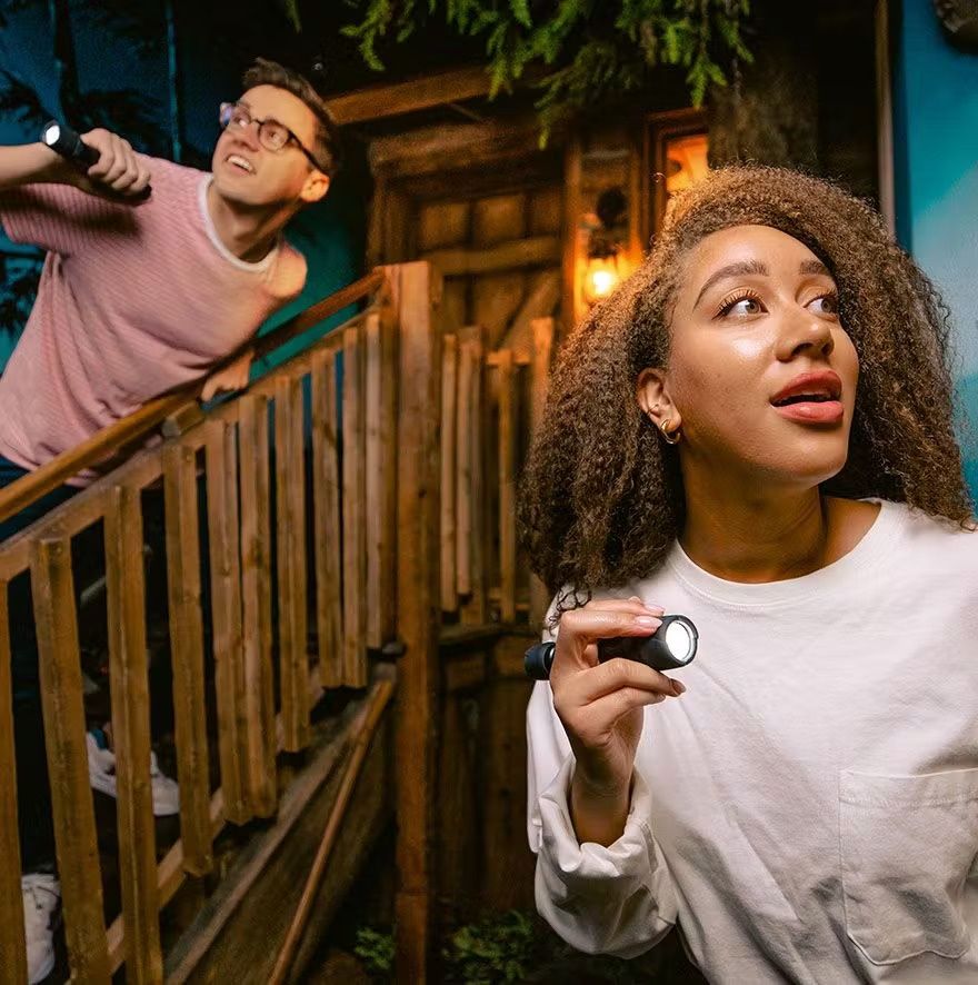 in-the-dim-room-two-escape-room-players-scour-for-clues-with-their-flashlights