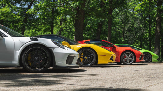 lineup on back roads of luxury cars
