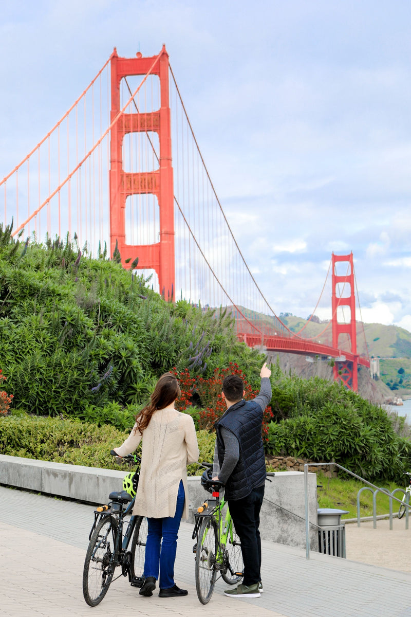 man and woman looking at goldne gate bridge