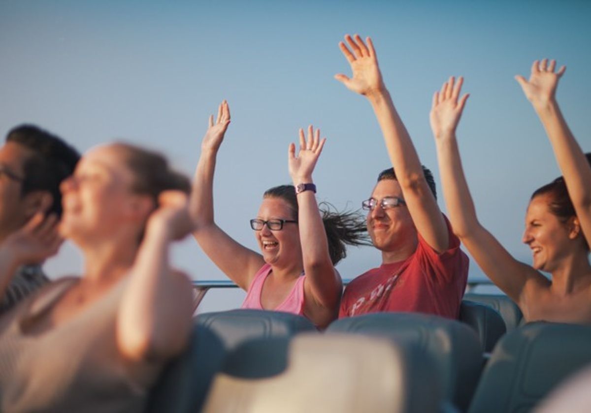 man-and-woman-with-their-arms-raised-during-lakefront-speedboat-tour