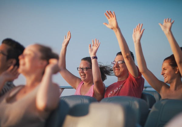 man-and-woman-with-their-arms-raised-during-lakefront-speedboat-tour
