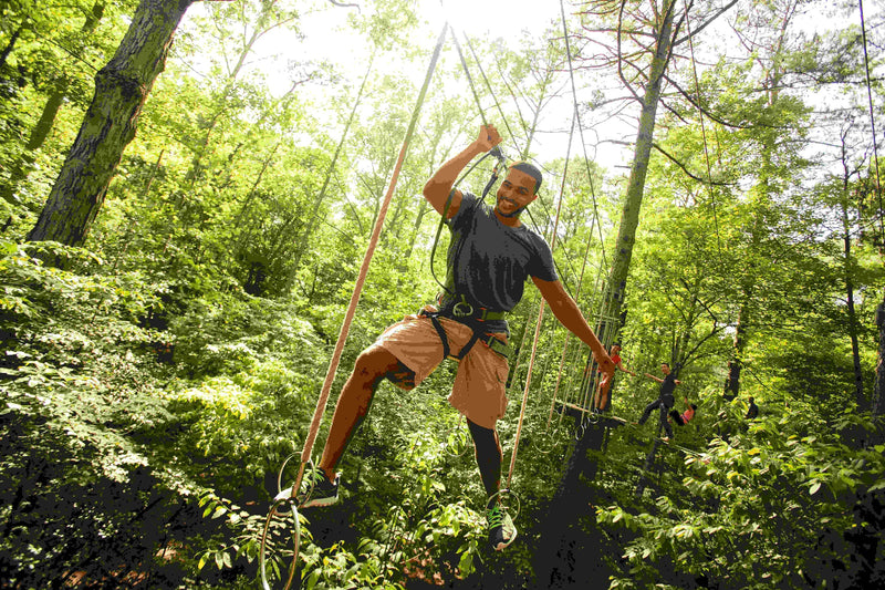man-in-blue-shirt-going-through-a-ropes-course-in-the-woods