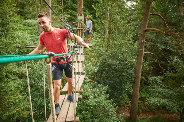 man in red shirt going across a wood bridge