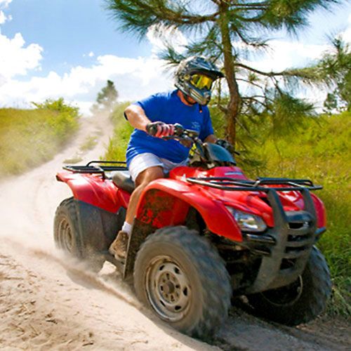 man-riding-atv-through-dirt
