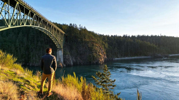 man-standing-at-bridge-in-front-of-lake