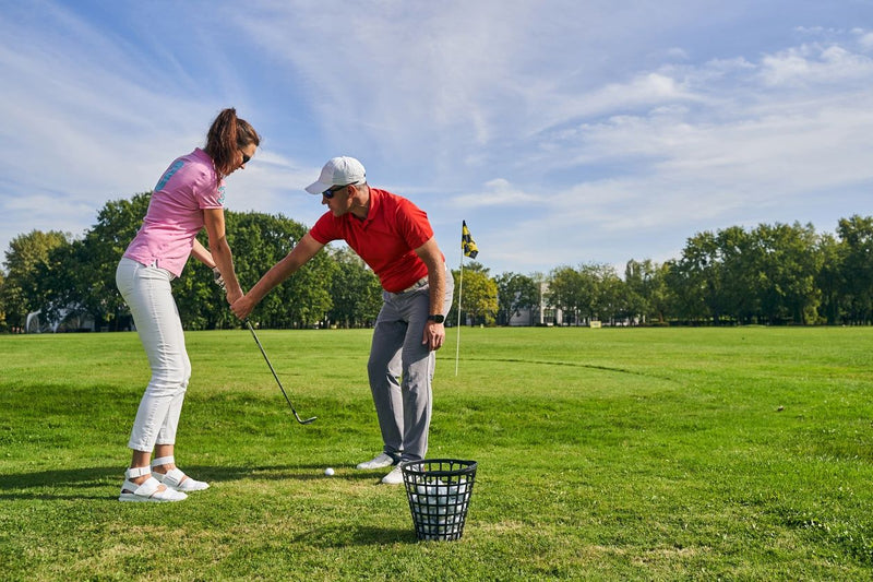 man tecahing woman golf
