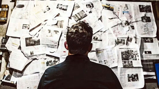 man staring at newspapers