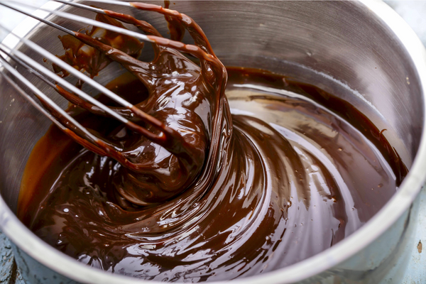 a person dipping a chocolate in caramel.jpg