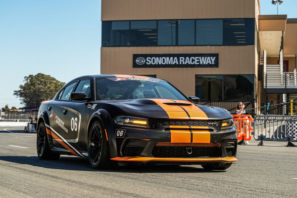 orange and black charger at racetrack