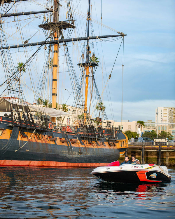people-in-speed-bota-next-to-pirate-ship