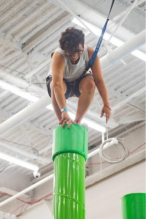 person on top of a climbing pole