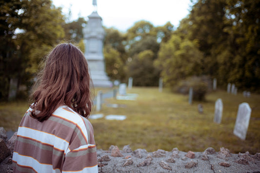 person in front of graveyard