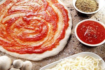 pizza sauce on marble ready to be topped