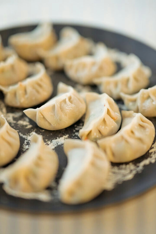 group of four people making dumplings