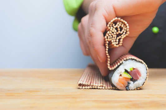 rolling sushi up close with salmon and tuna