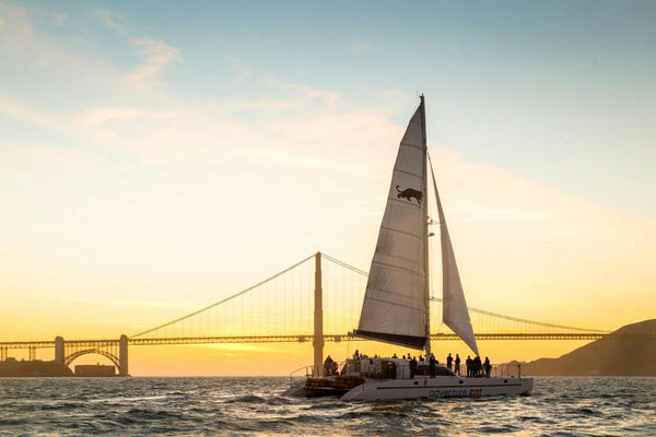 sailboat-in-the-sunset-with-bridge-in-background-jpg