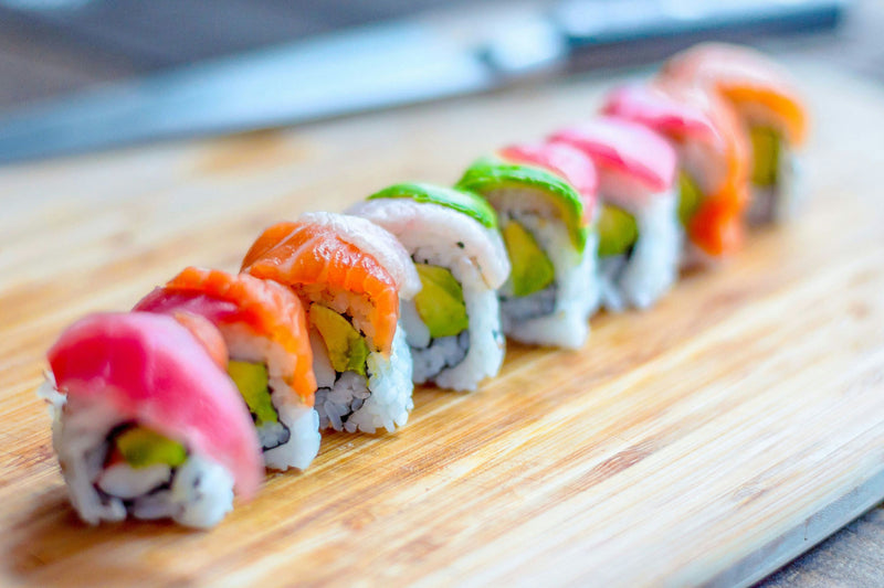 several colorful sushi on a wooden board.jpg