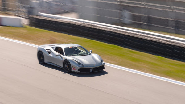 silver-ferrari-driving-fast-on-road