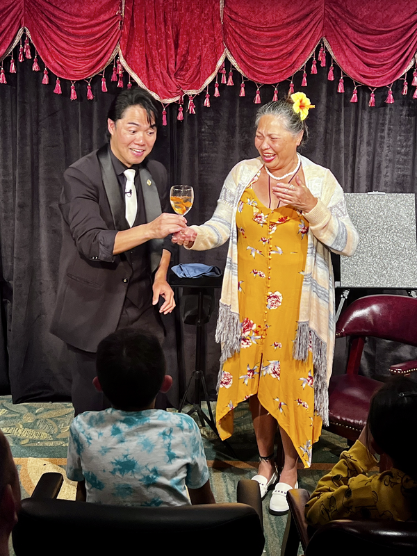 The Magical Mystery Show! At Hilton Waikiki Beach Hotel holding a glass.png