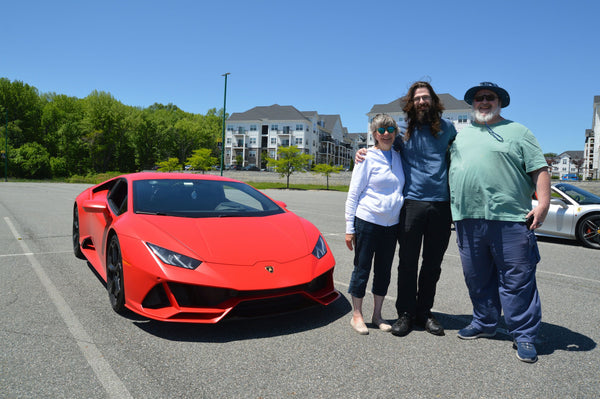 three people with red super car