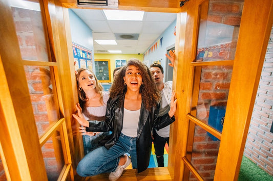 three friends looking through window in playground escape room