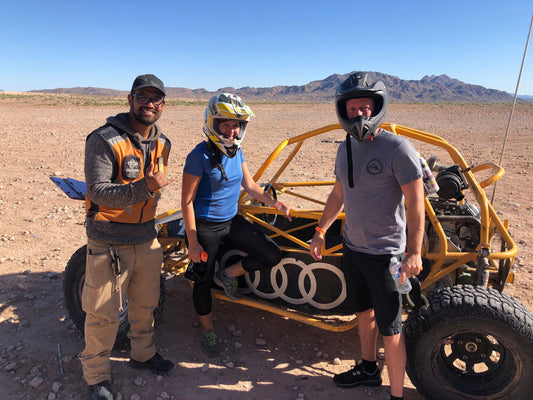 two men and one woman with a dune buggy