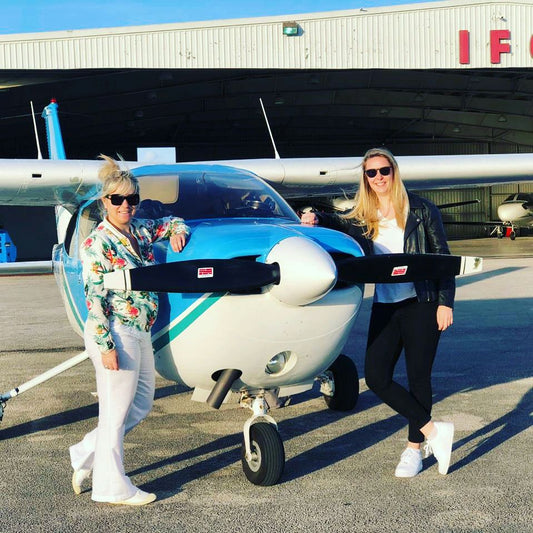 two women posed with  plane