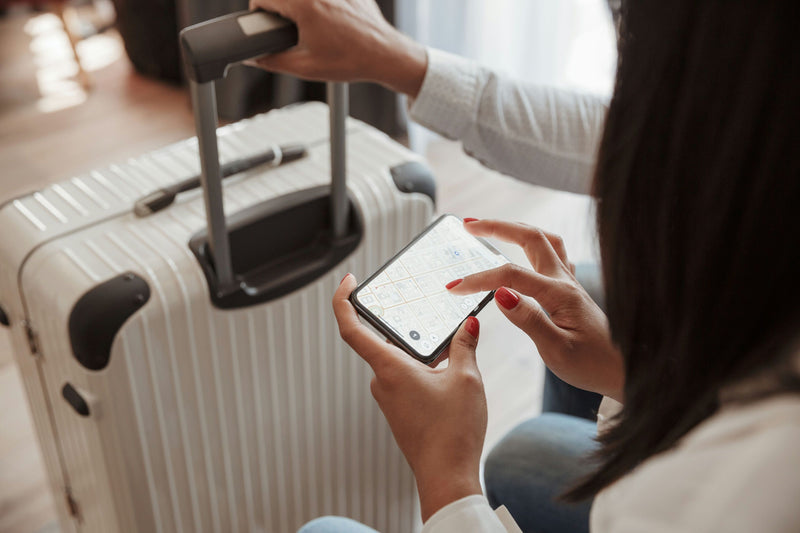 white-suitcase-and-phone-in-hand