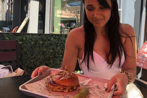 woman carrying burger on tray