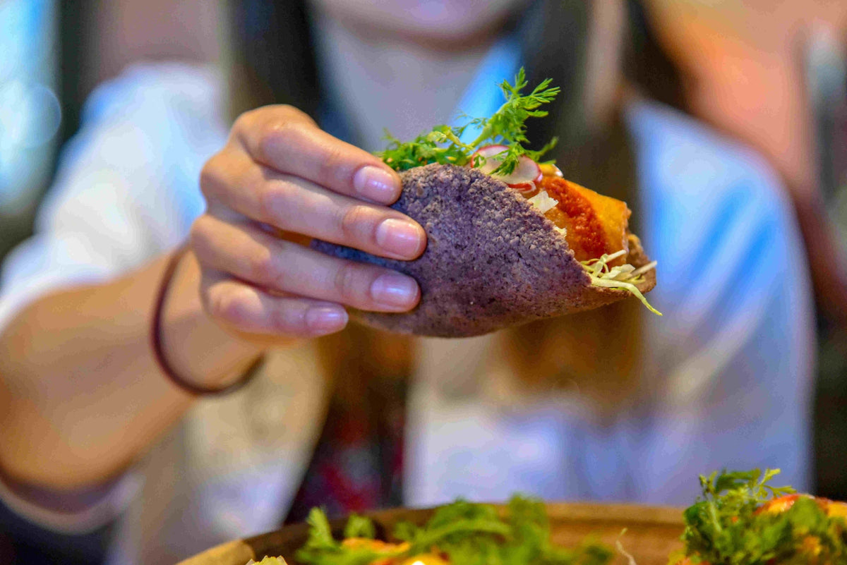woman-holding-a-taco-with-blue-tortilla