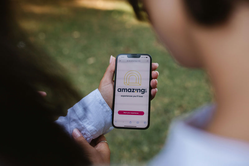 woman-in-blue-shirt-holding-phone-with-amazingco-app