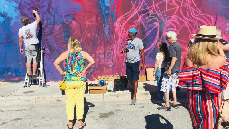 woman-in-yellow-pants-looking-at-a-pink-and-purple-wall