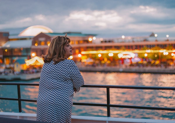 woman-looking-out-from-boat-to-chicago-lit-up-at-night
