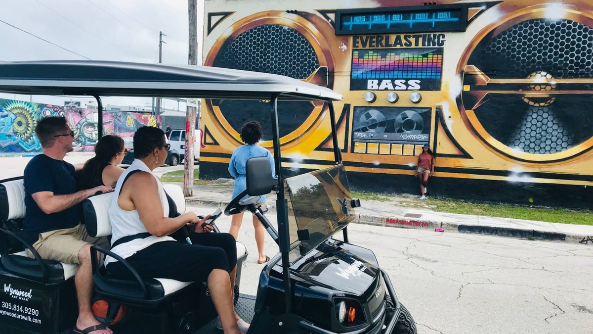 woman-on-golf-cart-looking-at-boombox-mural