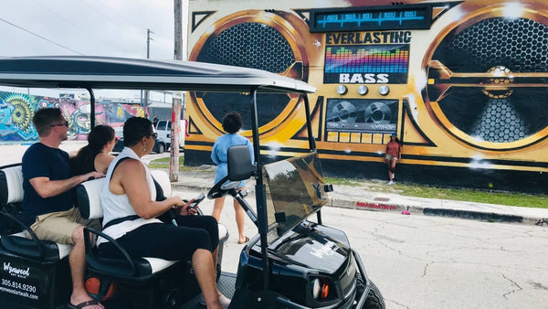 woman-on-golf-cart-looking-at-boombox-mural