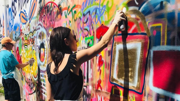 woman doing graffiti with black spray paint