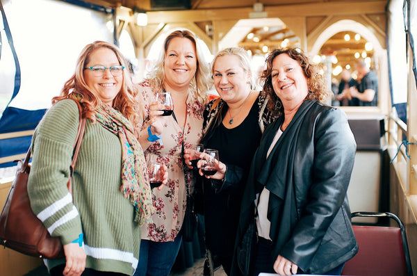 women with wine on train