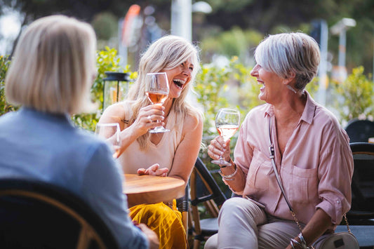 women laughing with rose wine