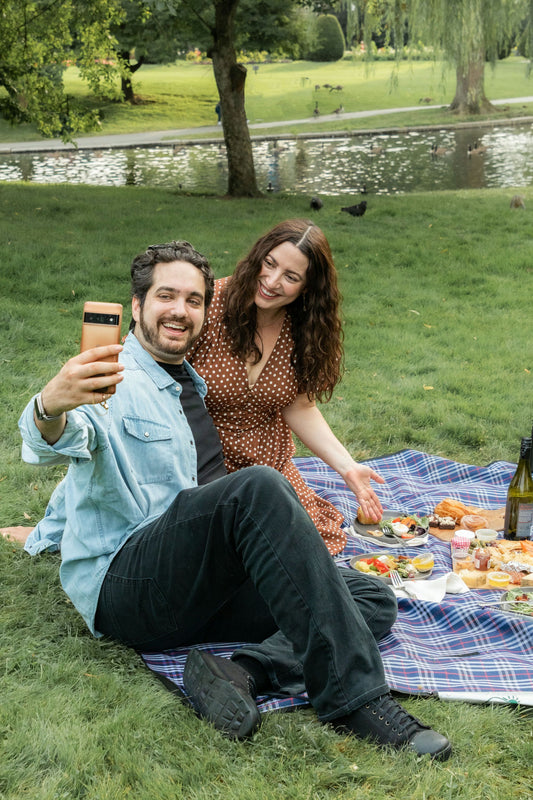 couple posing on blue picnic blanket