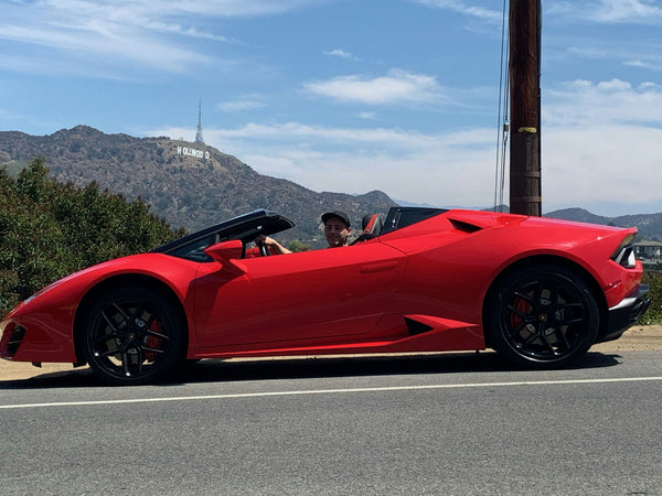 Leaning on lambo with hollywood sign in background