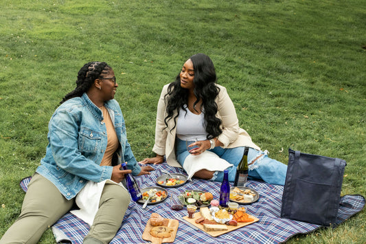 girls in jean and linen jackets on blue picnic blanket in park