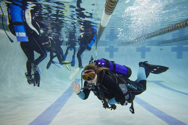 student waving underwater