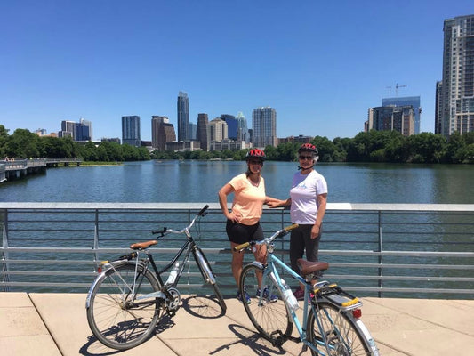 two girls with bikes and city background